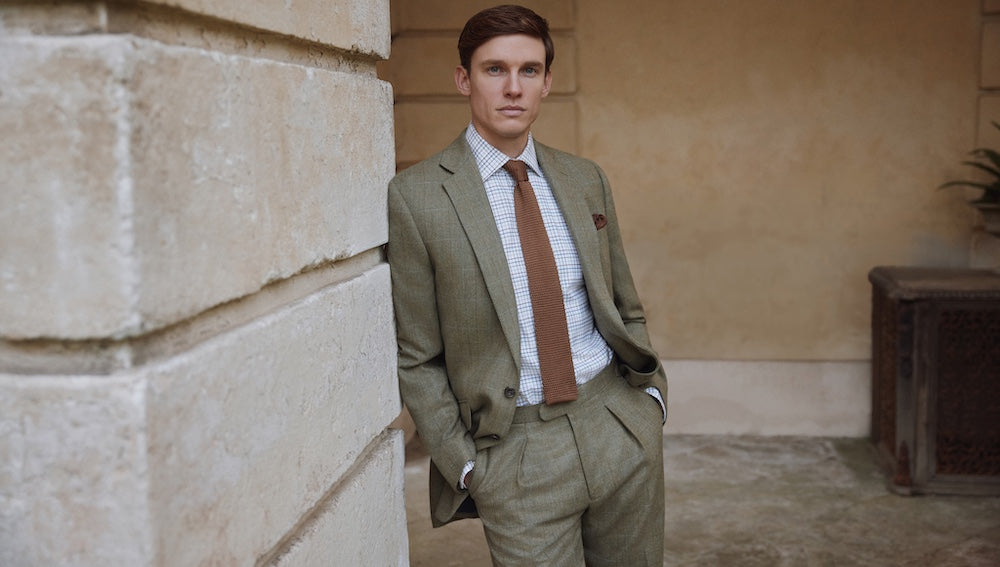 Man in the countryside wearing Oliver Brown shooting gear: breeks, shooting socks and garters, gilet and field coat all in the same limited-edition Nailhead Tweed.