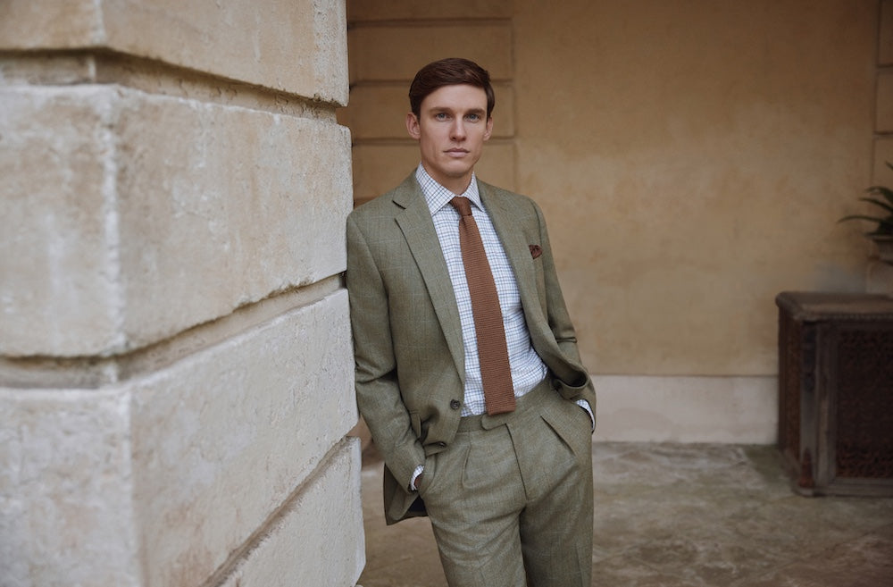 Man in the countryside wearing Oliver Brown shooting gear: breeks, shooting socks and garters, gilet and field coat all in the same limited-edition Nailhead Tweed.